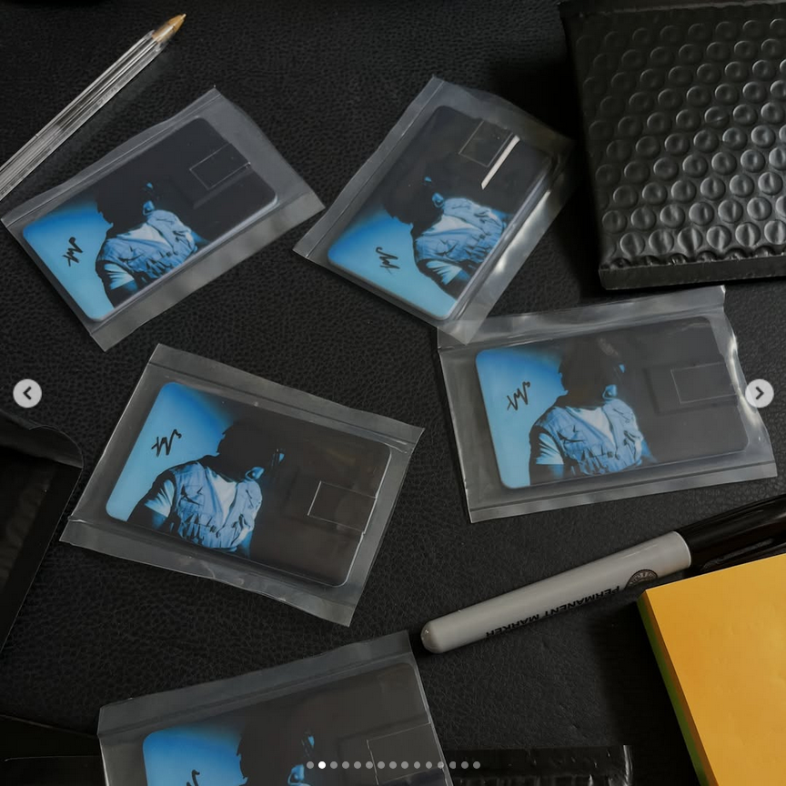 Signed Phyzi cards in protective sleeves beside a marker and mailing envelope